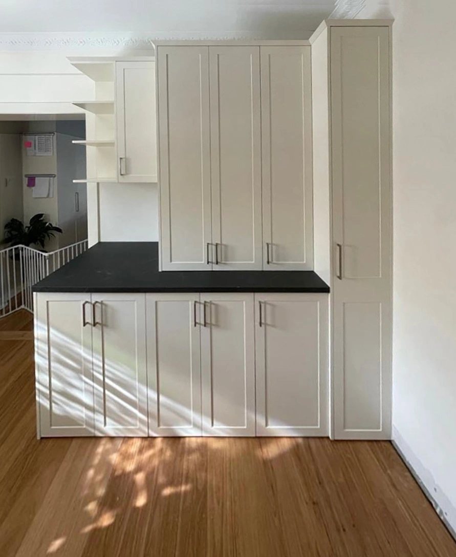 Contemporary kitchen with clean white cabinets and sophisticated black countertops