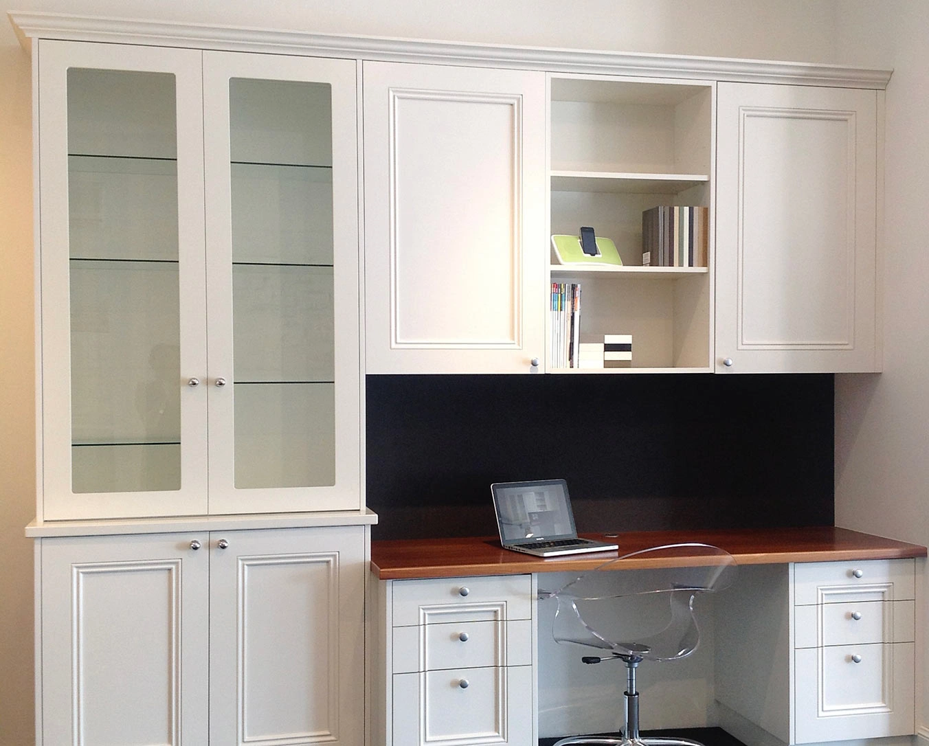 A modern white kitchen with a functional desk and stylish cabinets, emphasizing simplicity and elegance