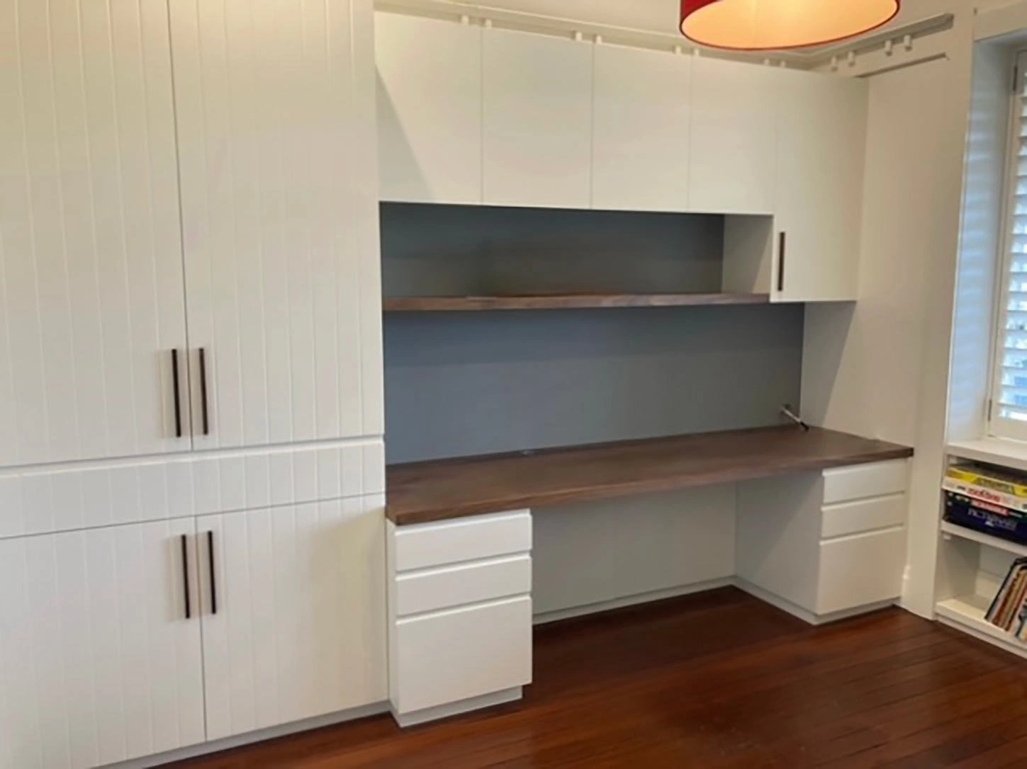 Modern white kitchen with a functional desk and stylish cabinets