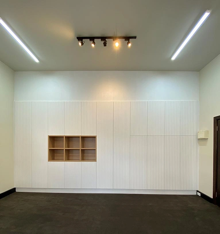 spacious room with white walls complemented by a wooden cabinet