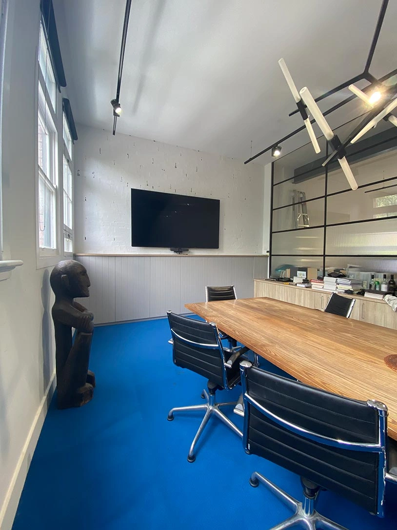 Modern conference room with a big table at the center and multiple chairs arranged around it for attendees