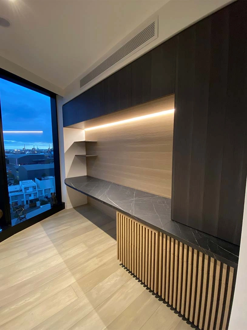 A contemporary office featuring a sleek desk positioned near a large window