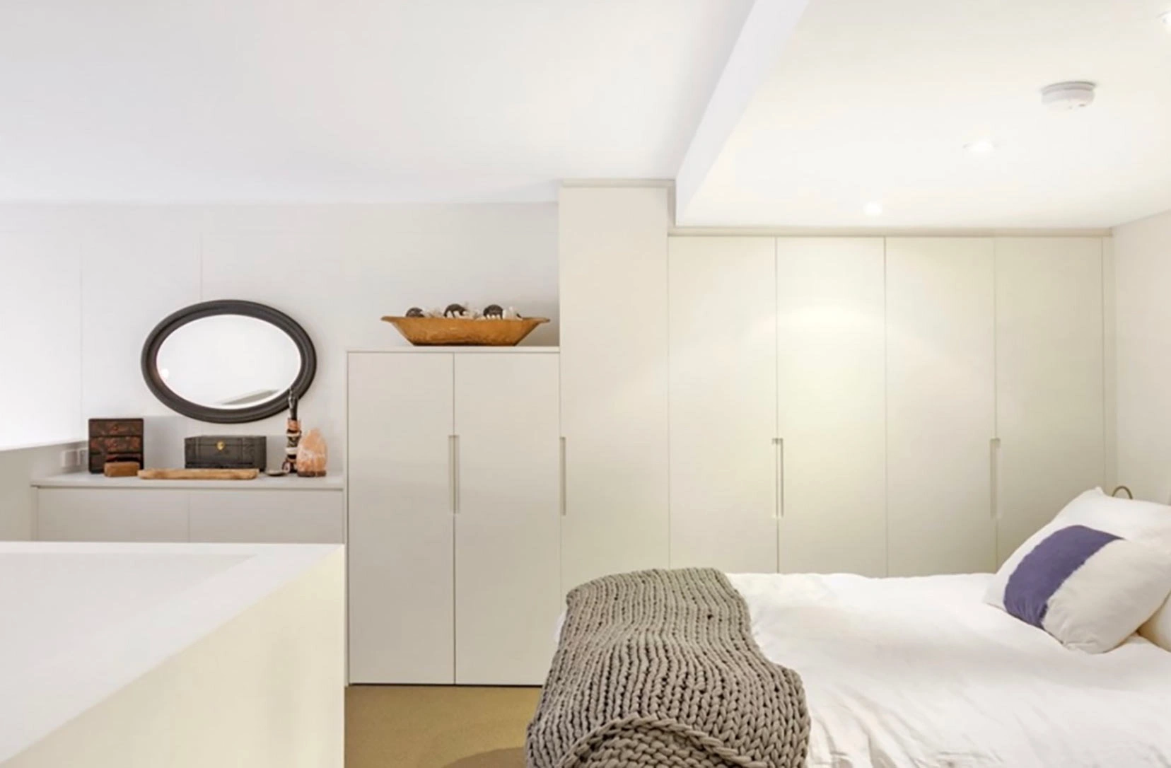 Bright bedroom with white walls and a comfortable bed