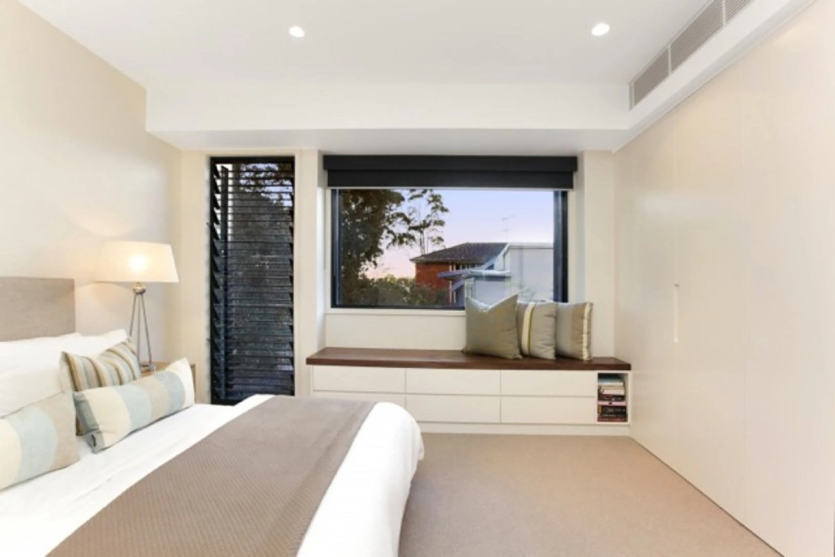 Stylish bedroom with a generous window allowing sunlight to stream in