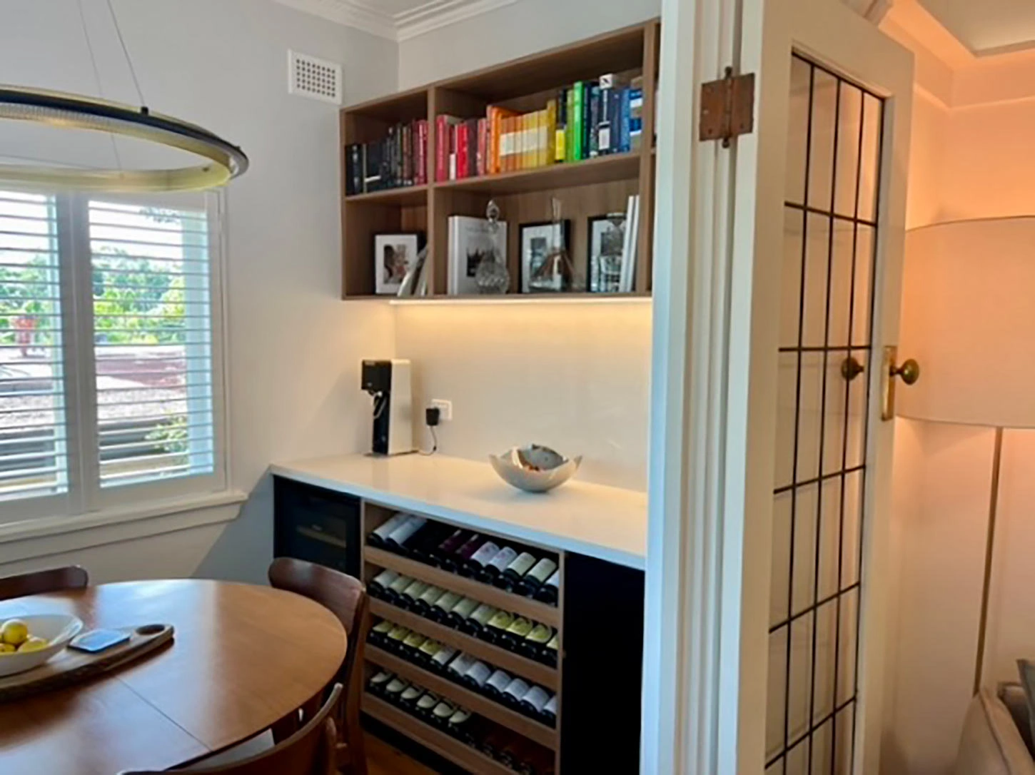 Modern kitchen with a spacious table and a decorative wine rack