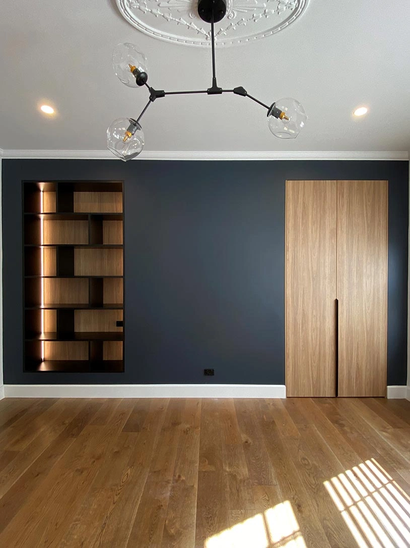 Modern room with sleek wooden flooring and a dramatic black wall