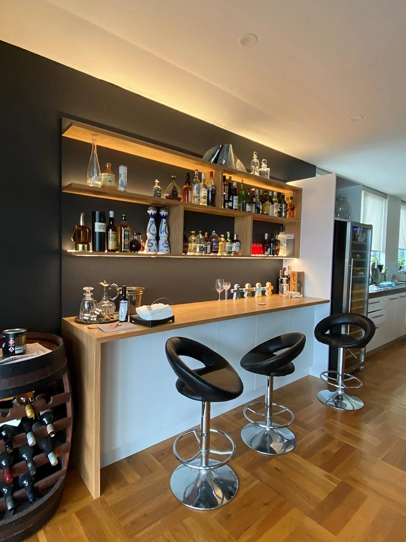 A contemporary home bar designed with elegant black and white details