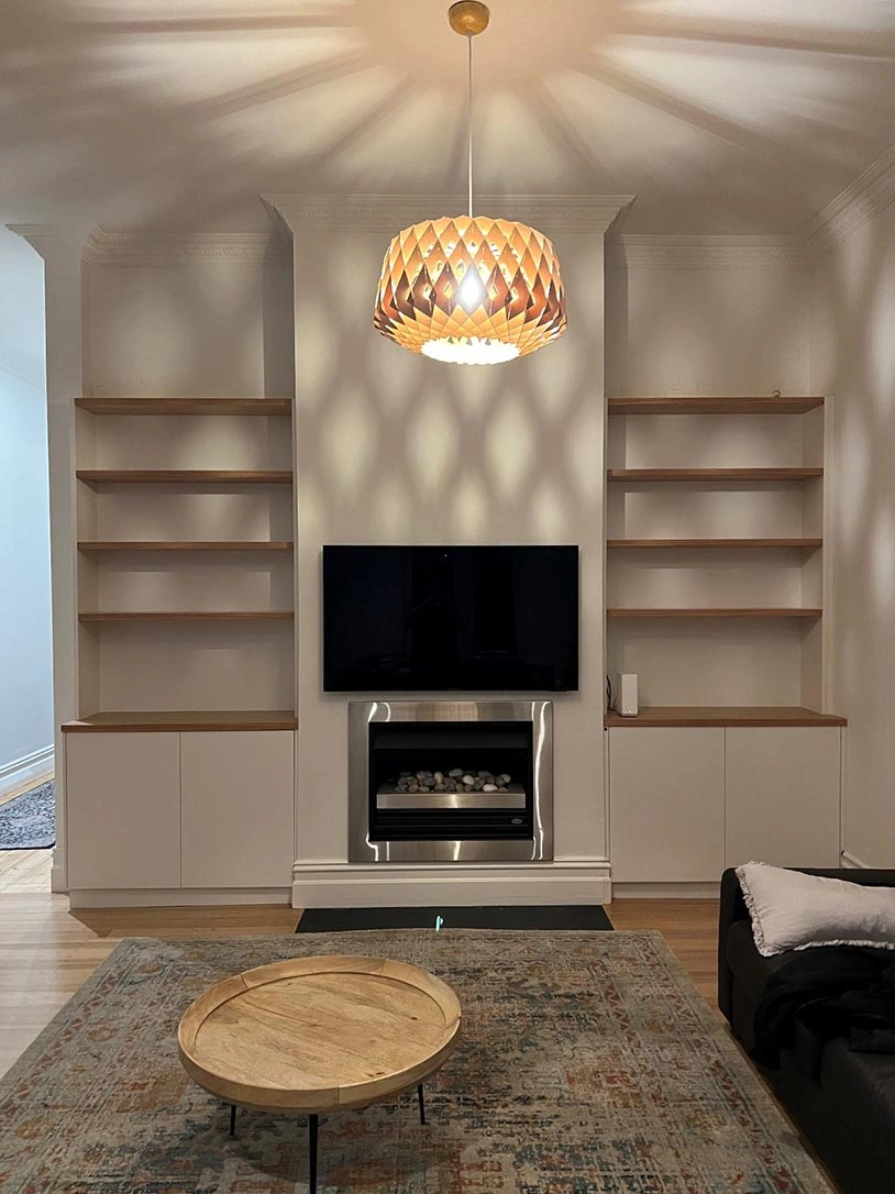 Comfortable living room showcasing a fireplace and shelves adorned with books and personal mementos