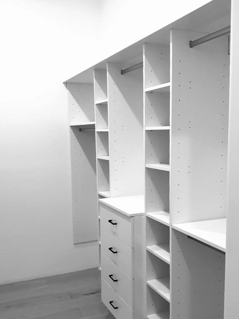 A clean white closet with multiple shelves and drawers for easy organization