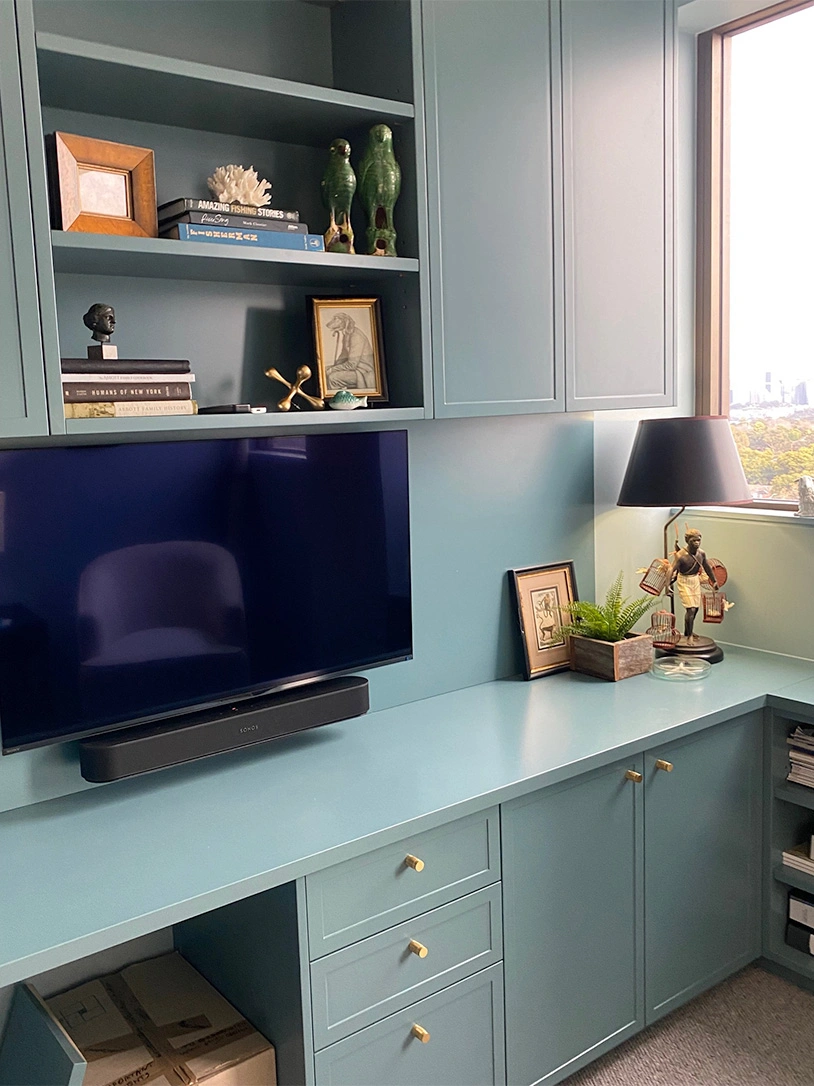 A stylish blue home office equipped with a flat screen TV, blending functionality with contemporary design