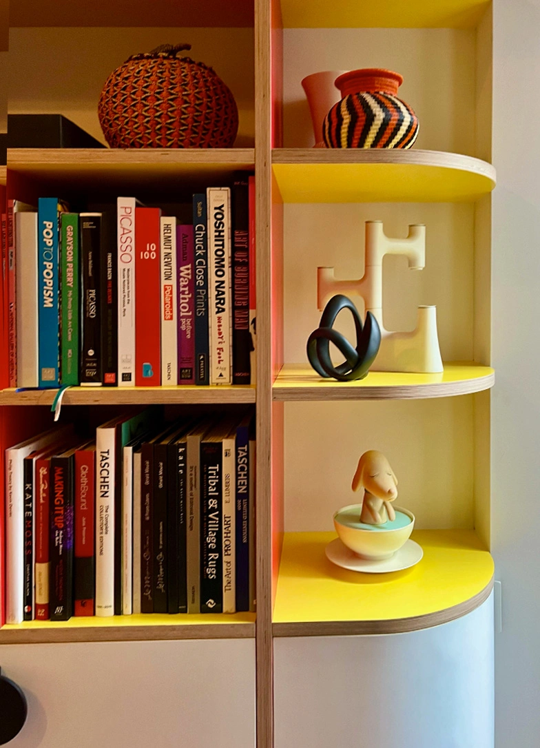 Bookshelf filled with various books and a decorative vase placed on top, showcasing a cozy reading space