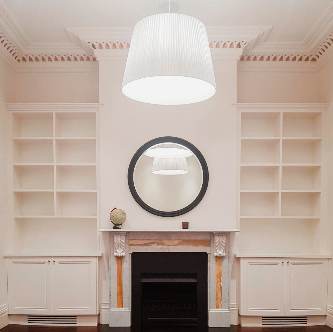 Elegant white living room showcasing a fireplace and a mirror