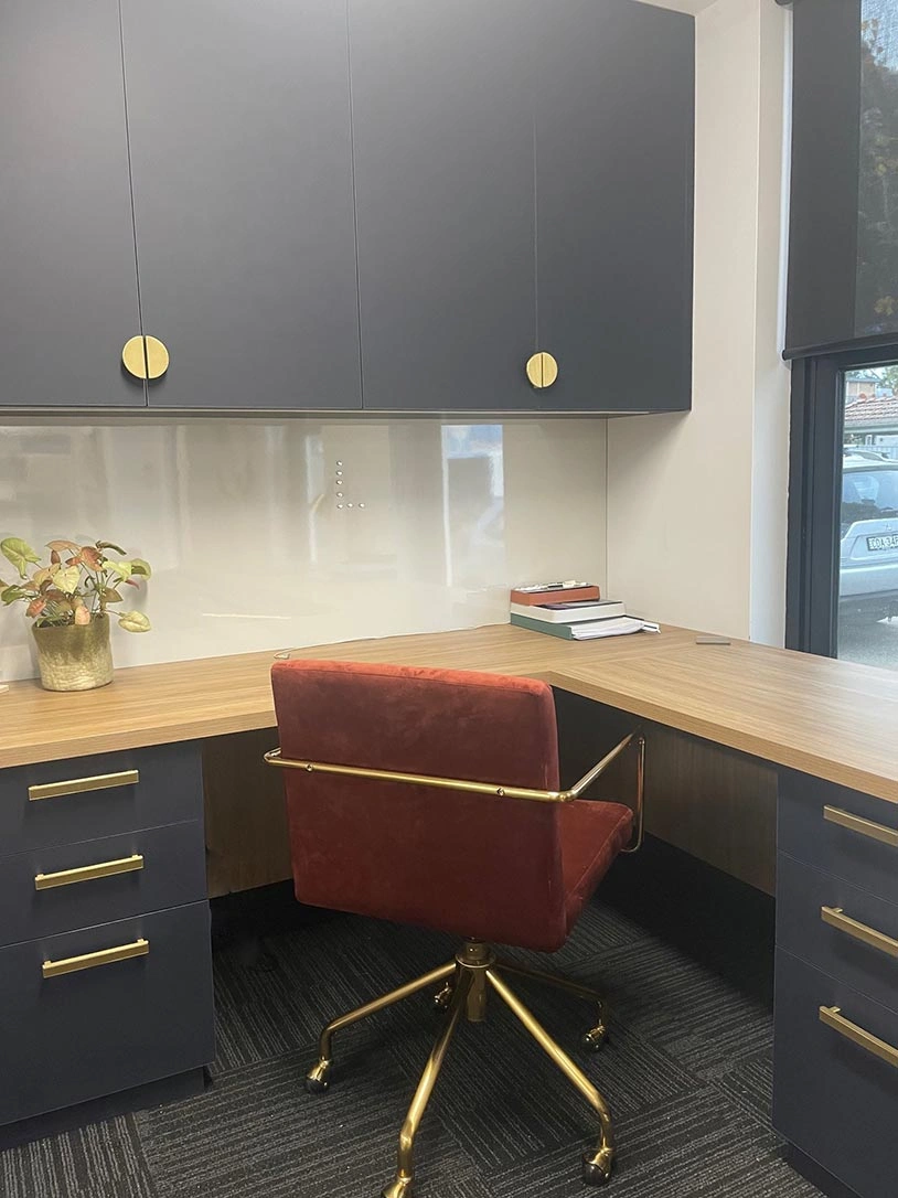 A modern office setup featuring a desk, a chair, and a cabinet, creating a functional workspace