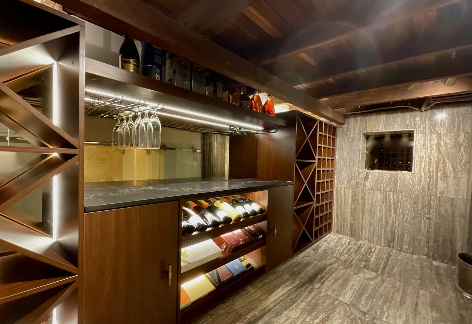 A wine cellar featuring elegant glass doors and a staircase, showcasing a collection of fine wines in a stylish setting