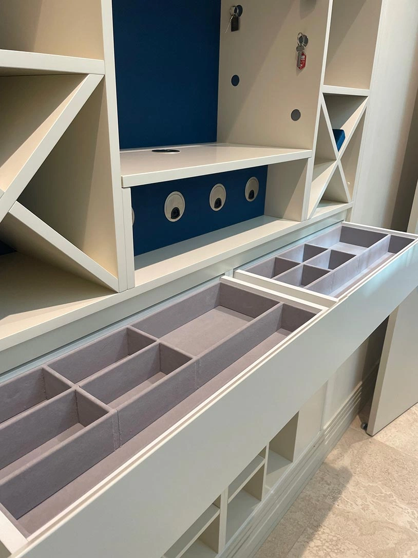 A white cabinet featuring multiple drawers and a spacious shelf for storage and organization