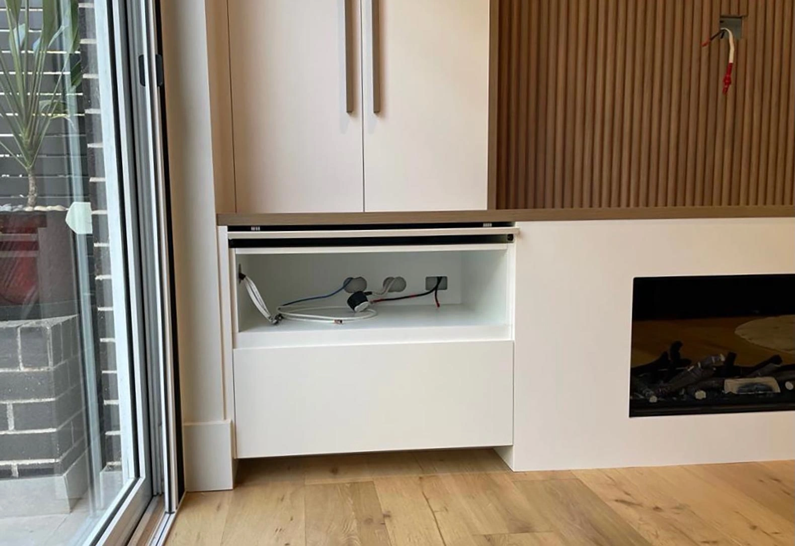 Elegant white cabinet integrated with a fireplace, enhancing the room's charm and warmth