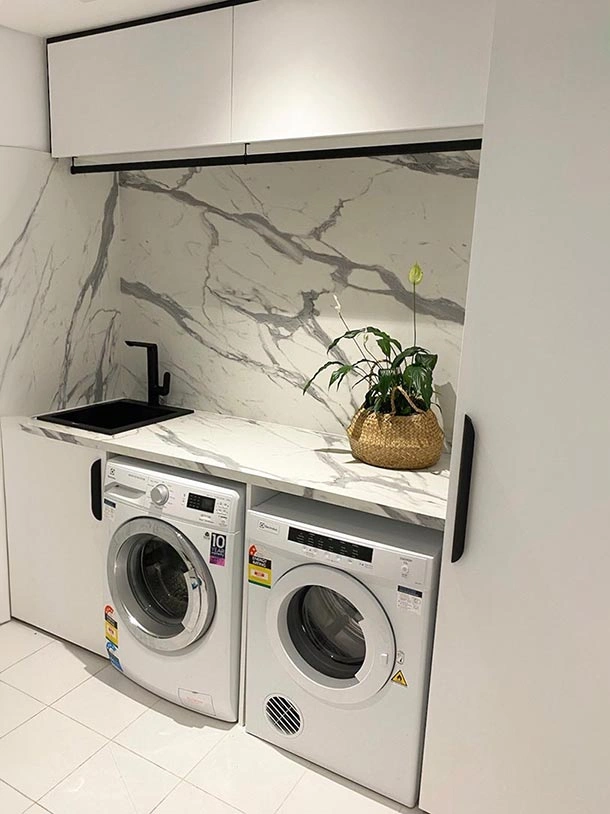 A clean, white laundry room equipped with a washer and dryer, reflecting a bright and efficient laundry space