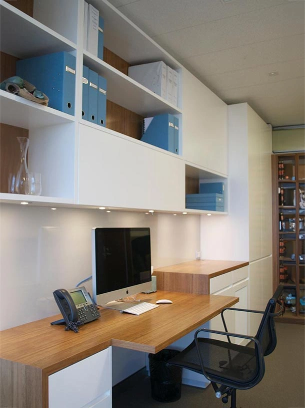 Stylish home office environment with a functional desk, a supportive chair, and shelves displaying various items and books