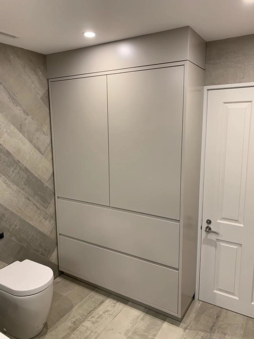 A clean bathroom featuring a toilet, sink, and a storage cabinet for toiletries and essentials