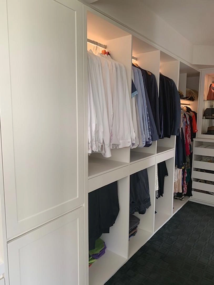 Modern closet featuring white cabinets and a closed door