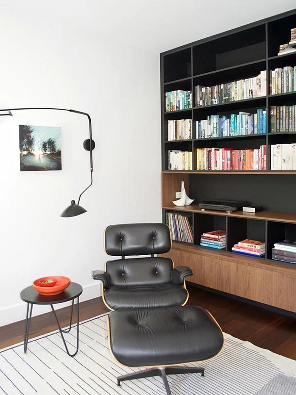 Modern home office design with a plush leather chair and neatly arranged bookshelves