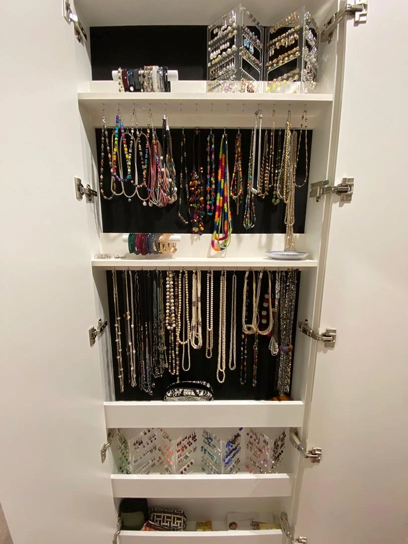 A neatly organized closet showcasing an array of jewelry and assorted items