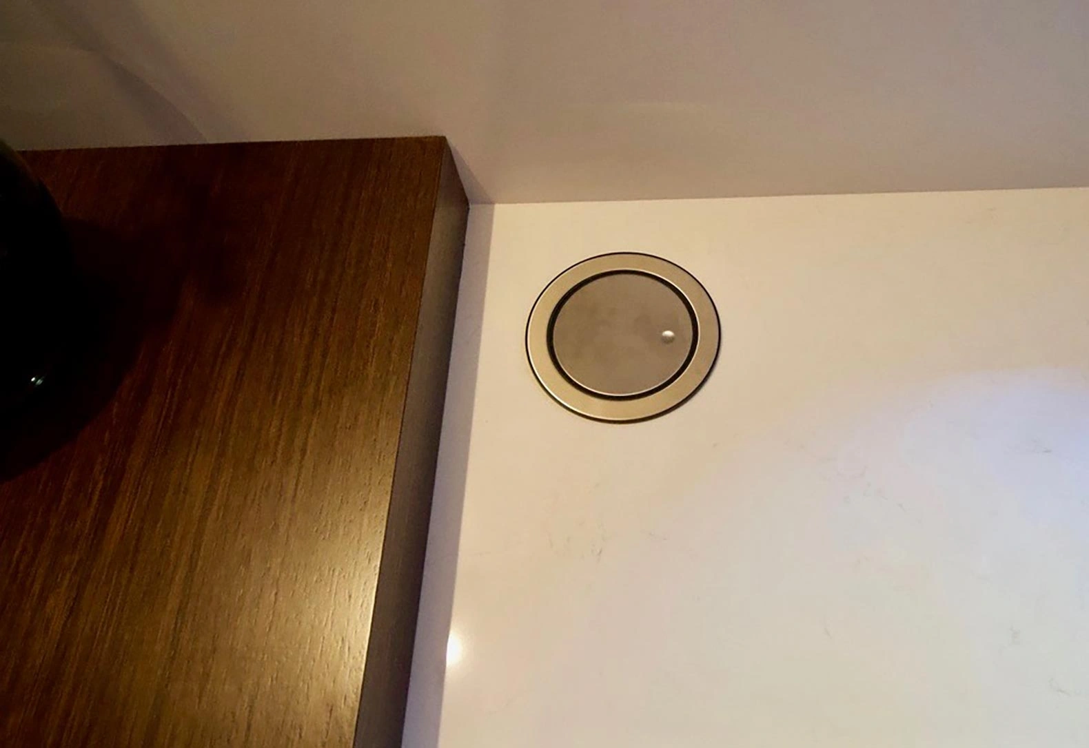 A wall-mounted white speaker, designed to enhance sound quality while maintaining a minimalist aesthetic