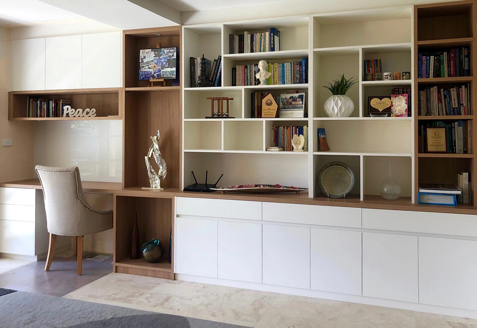 Stylish home office with extensive bookshelves and a desk, creating an inviting space for reading and working