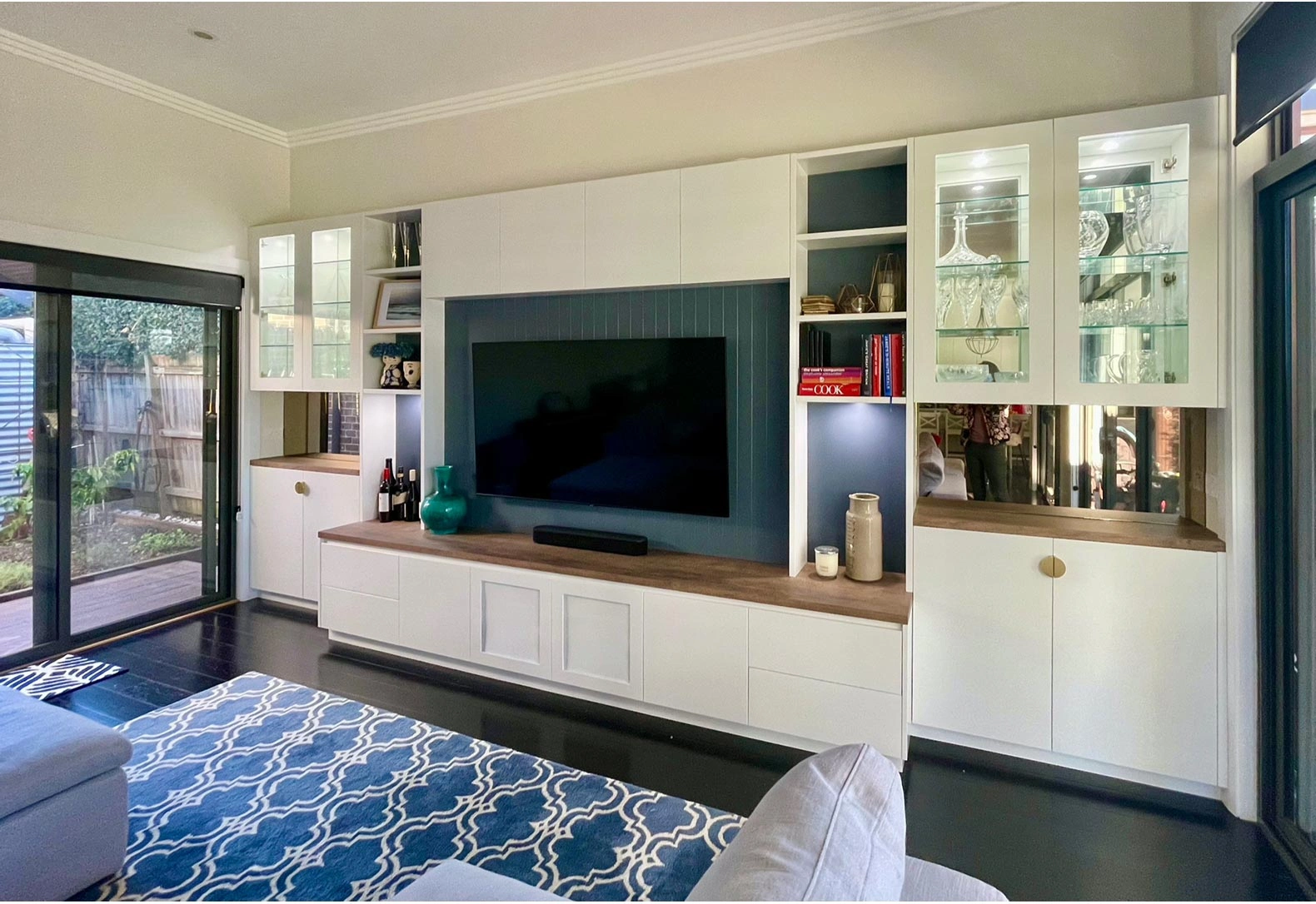 Stylish living room showcasing a TV and elegant white cabinets