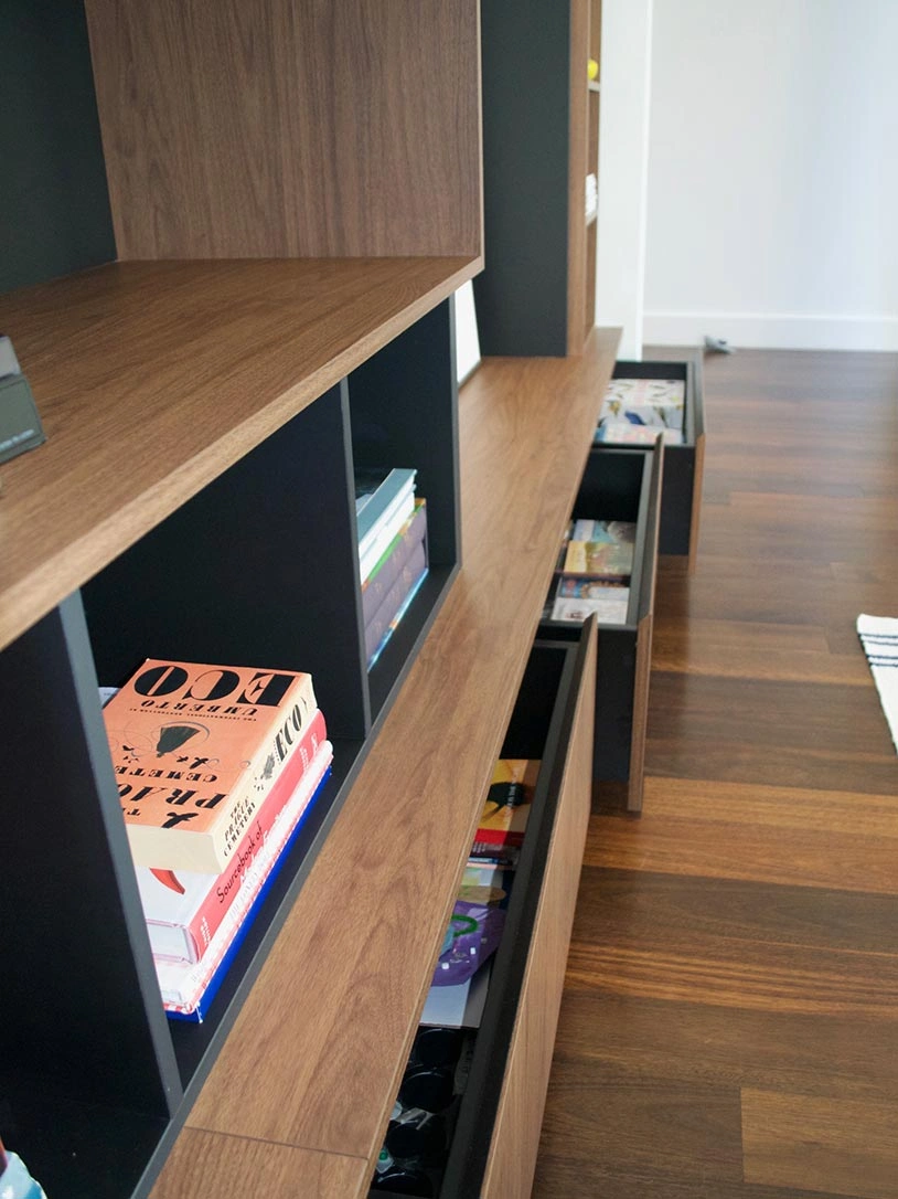 A bookshelf filled with various books alongside a computer