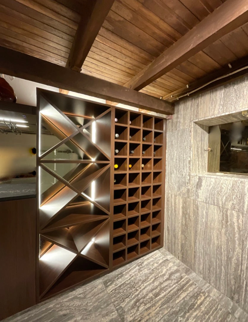 Interior view of a wine cellar showcasing a wooden ceiling and shelves stocked with an assortment of wine bottles