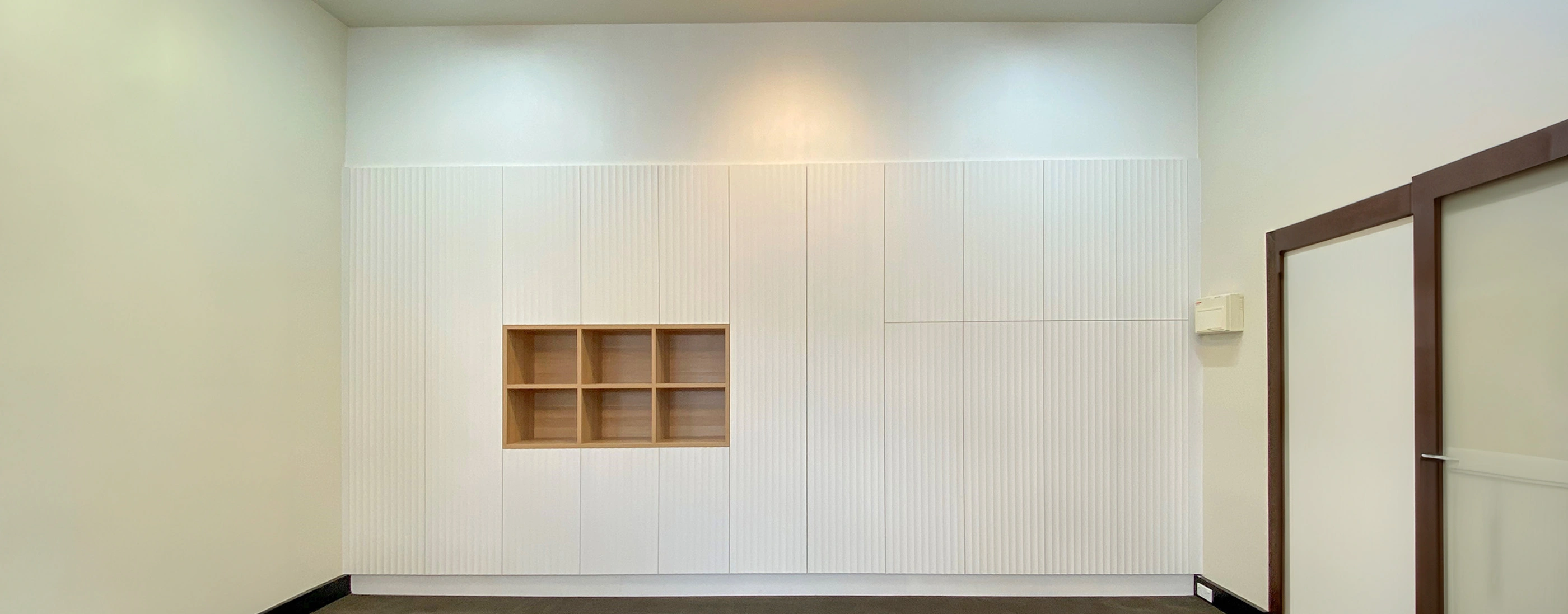 Hallway with a wooden door and neatly arranged shelves