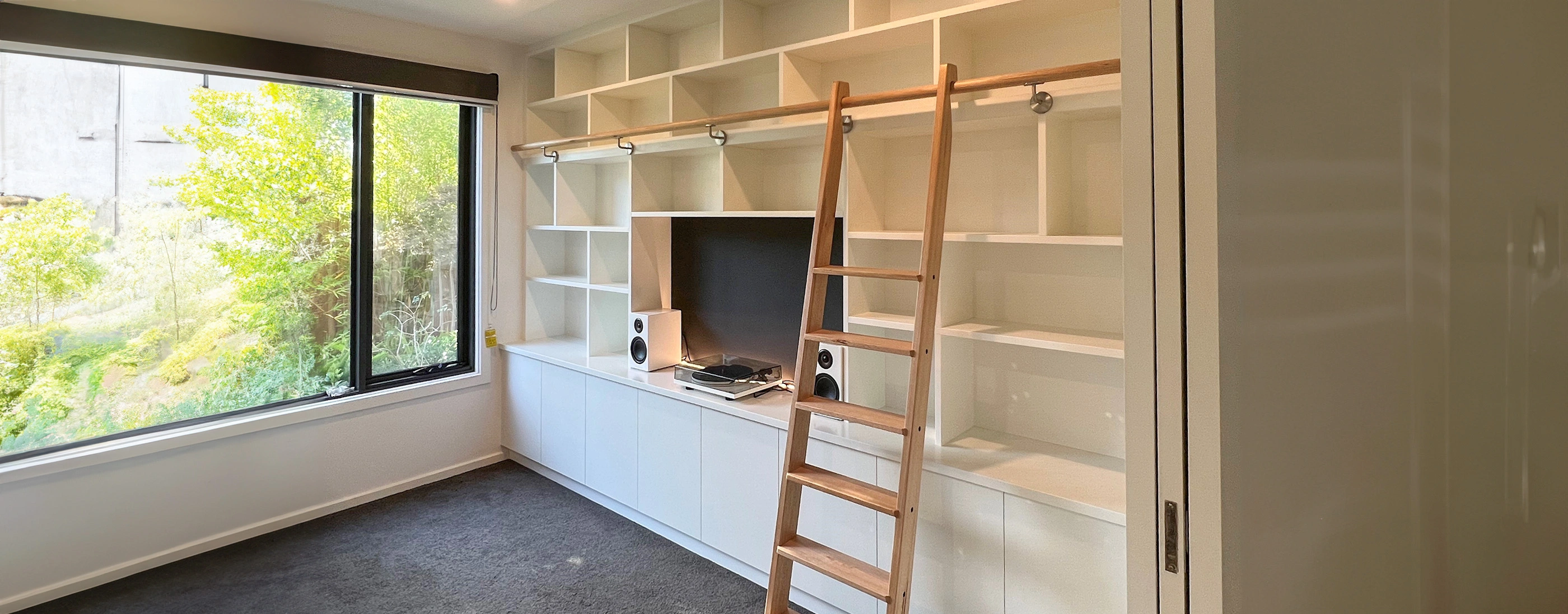 A ladder is placed in front of a window in a room, symbolizing access to elevated spaces or ongoing renovations