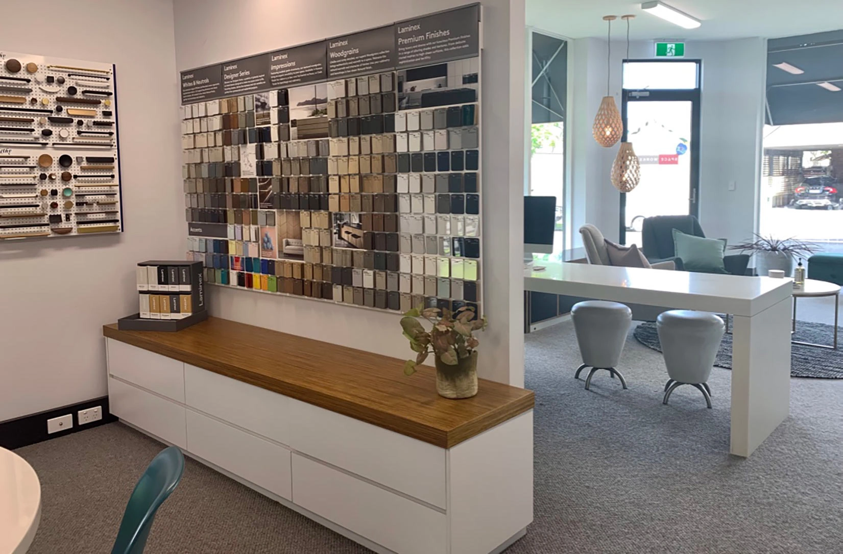 Interior view of a room with a table and chairs, complemented by a wall showcasing an array of sample materials