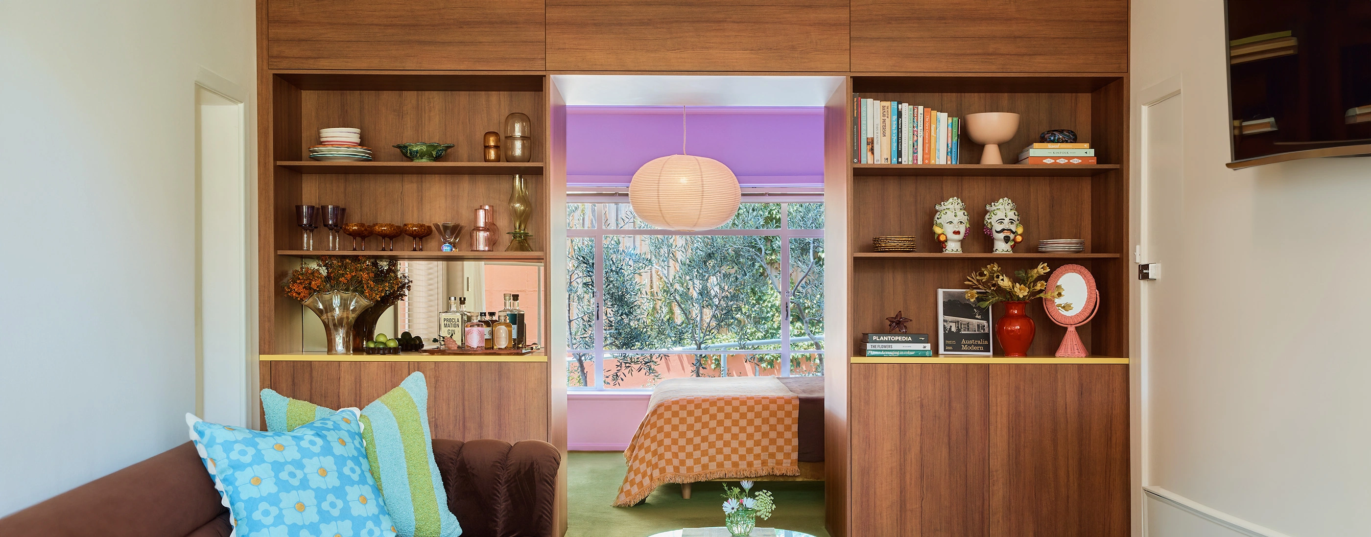 A warm living room scene with a plush couch, lined bookshelves, and a sunny window creating a welcoming atmosphere