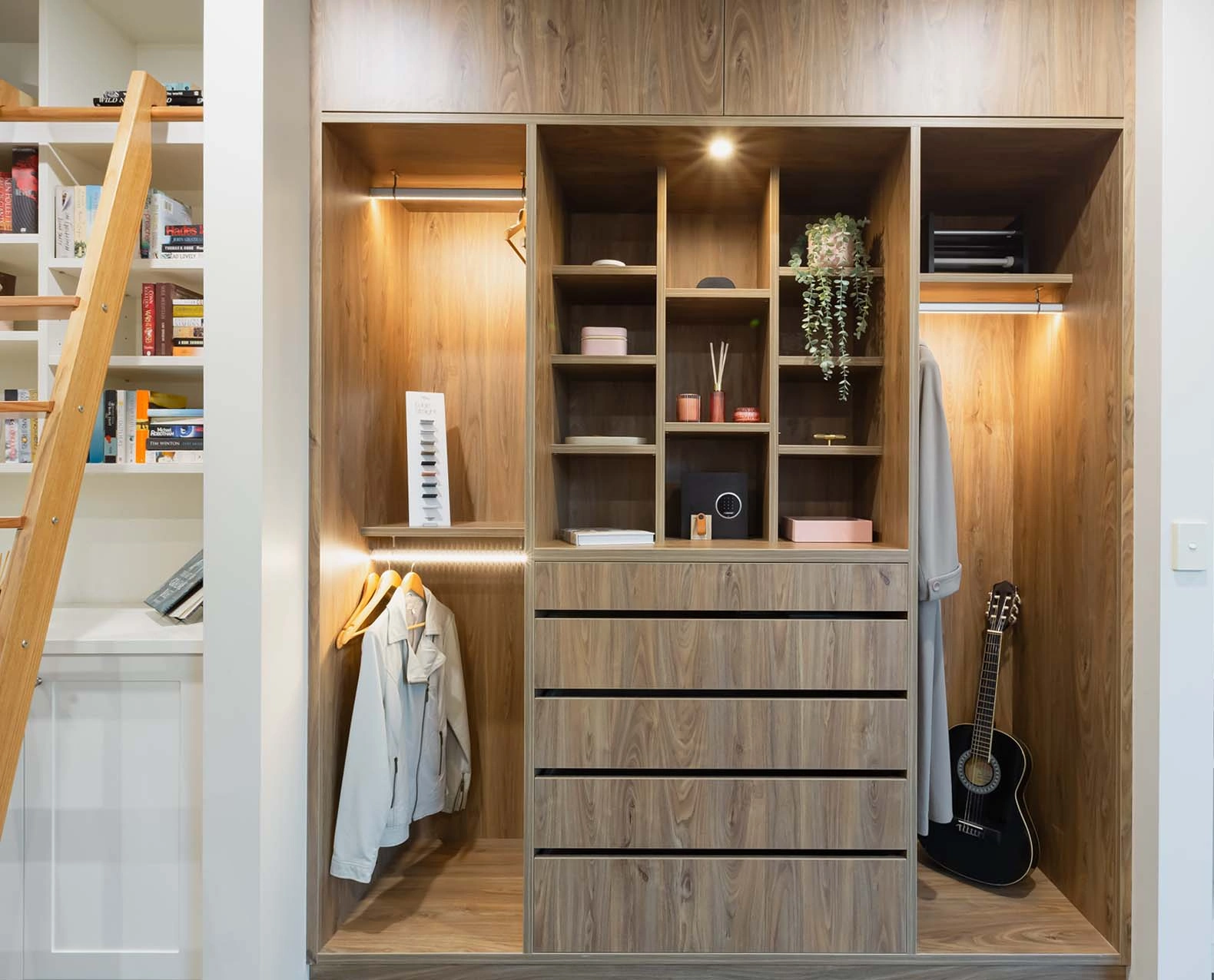 An organized closet featuring a guitar and various clothing items, highlighting a personal style and musical interest