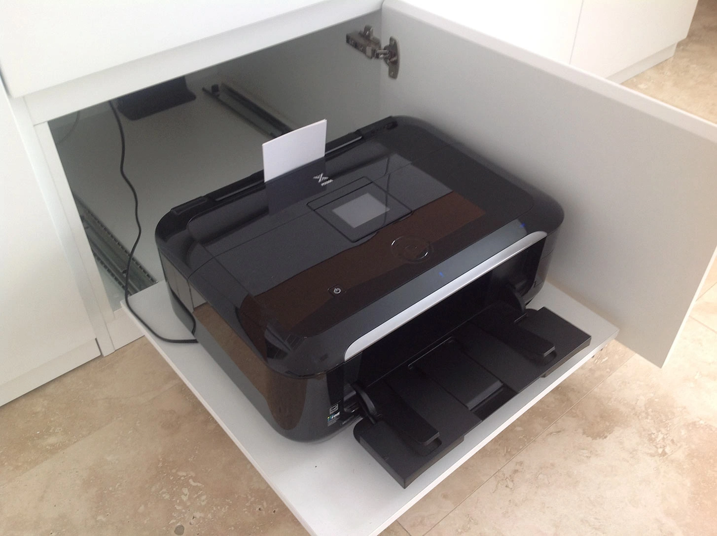 A printer neatly placed in a cabinet, with a drawer below for easy access to supplies and documents