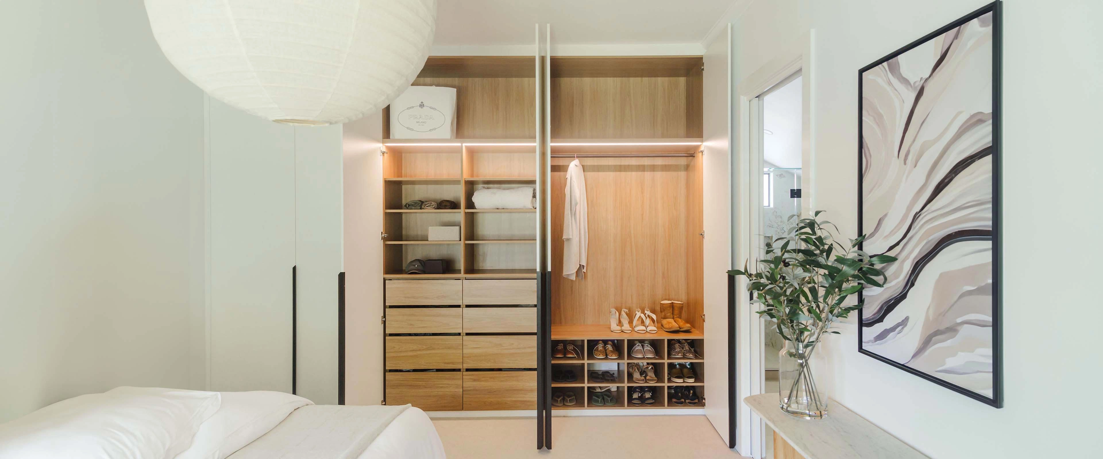 A compact bedroom showcasing a neatly made bed and a closet, emphasizing simplicity and functionality