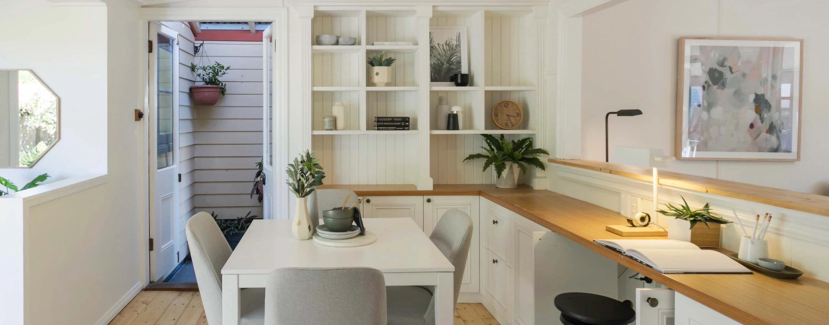 A modern kitchen featuring a desk and a dining table, showcasing a functional and inviting space for cooking and dining