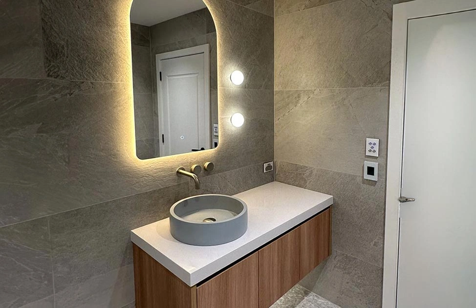 Well-lit bathroom with a minimalist sink and a mirror, creating a fresh and inviting atmosphere